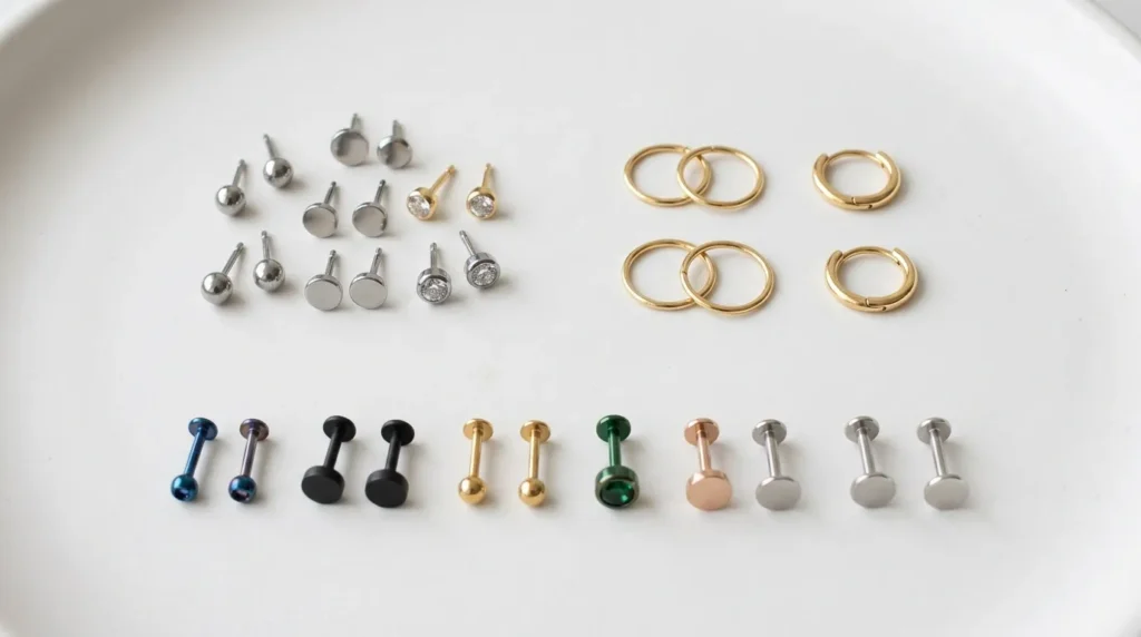Collection of hospital-approved small stud earrings and tiny hoops arranged on a white background — safe earring options for nurses